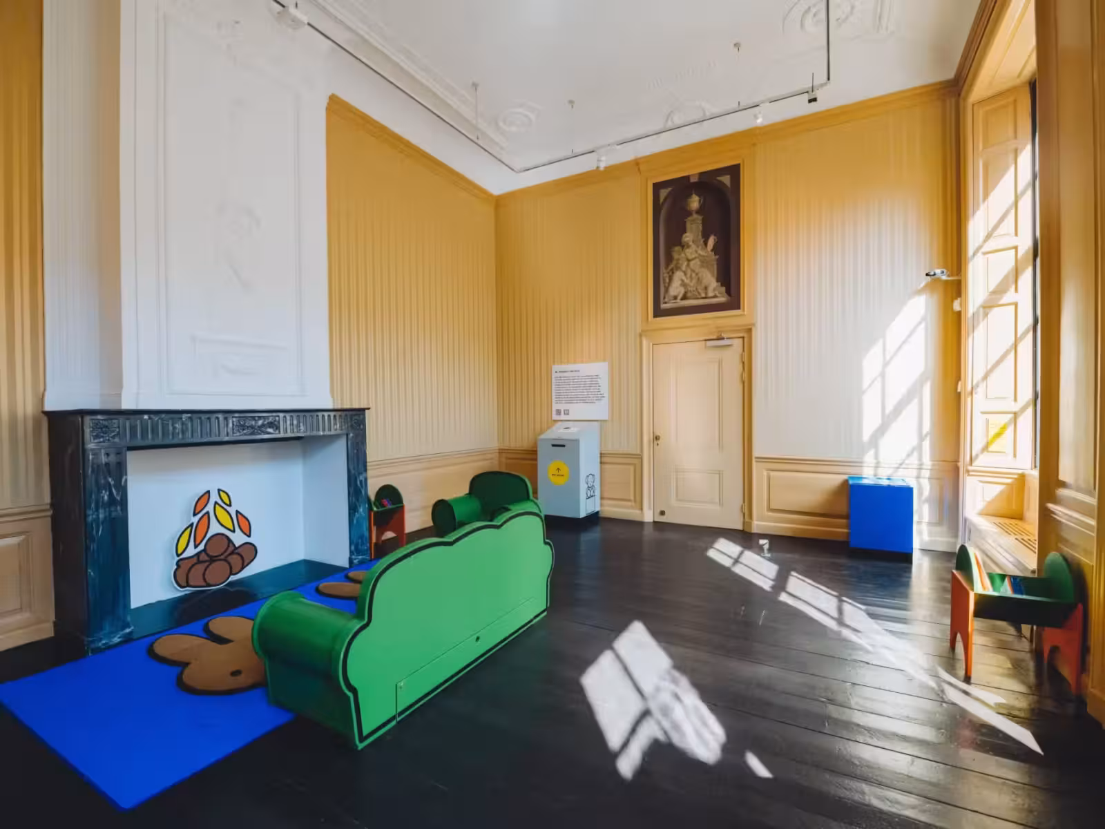 Speelhoek met groene bank in een historische zaal
